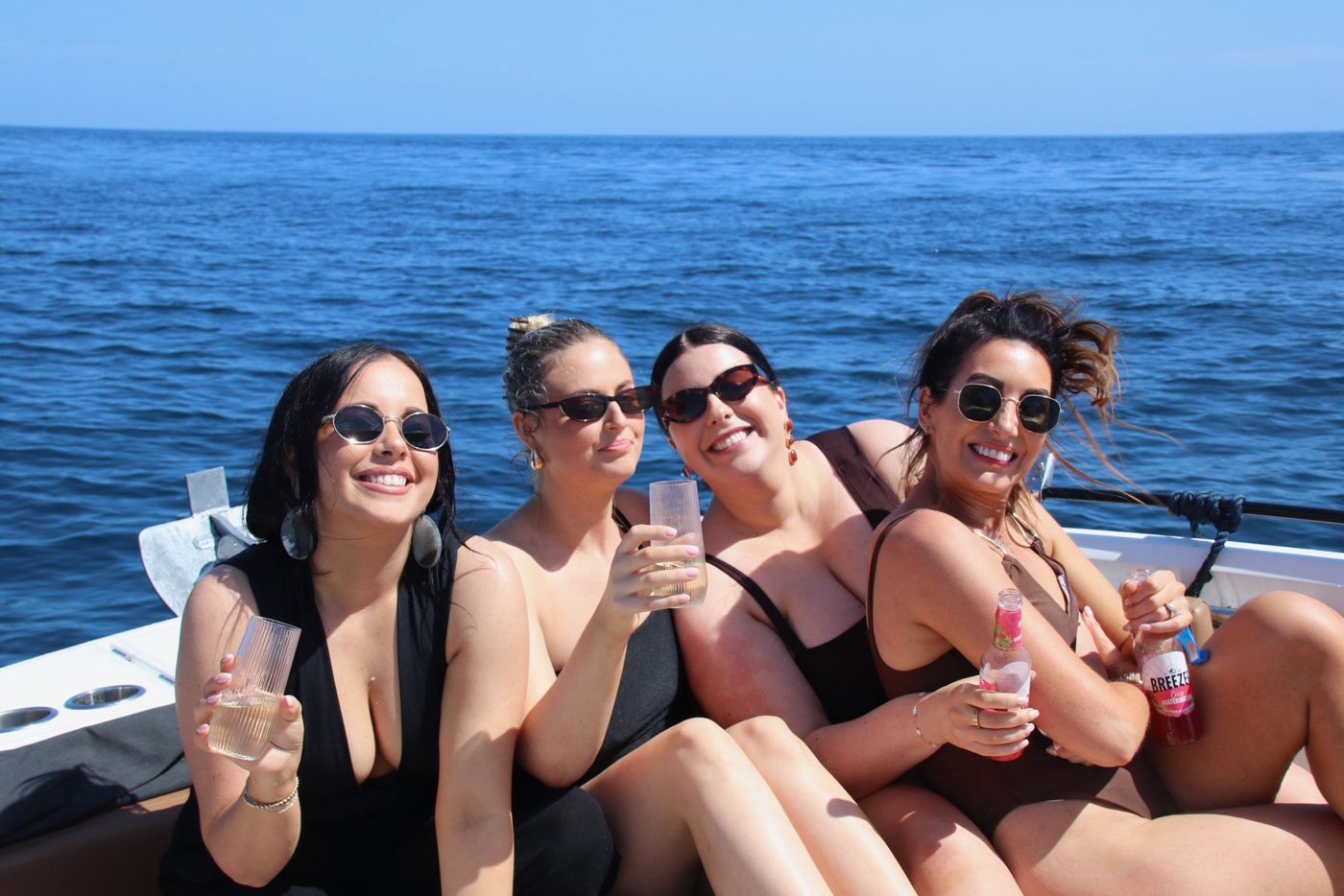 Four friends raising their glasses on deck on a birthday charter with Visitar Marbella