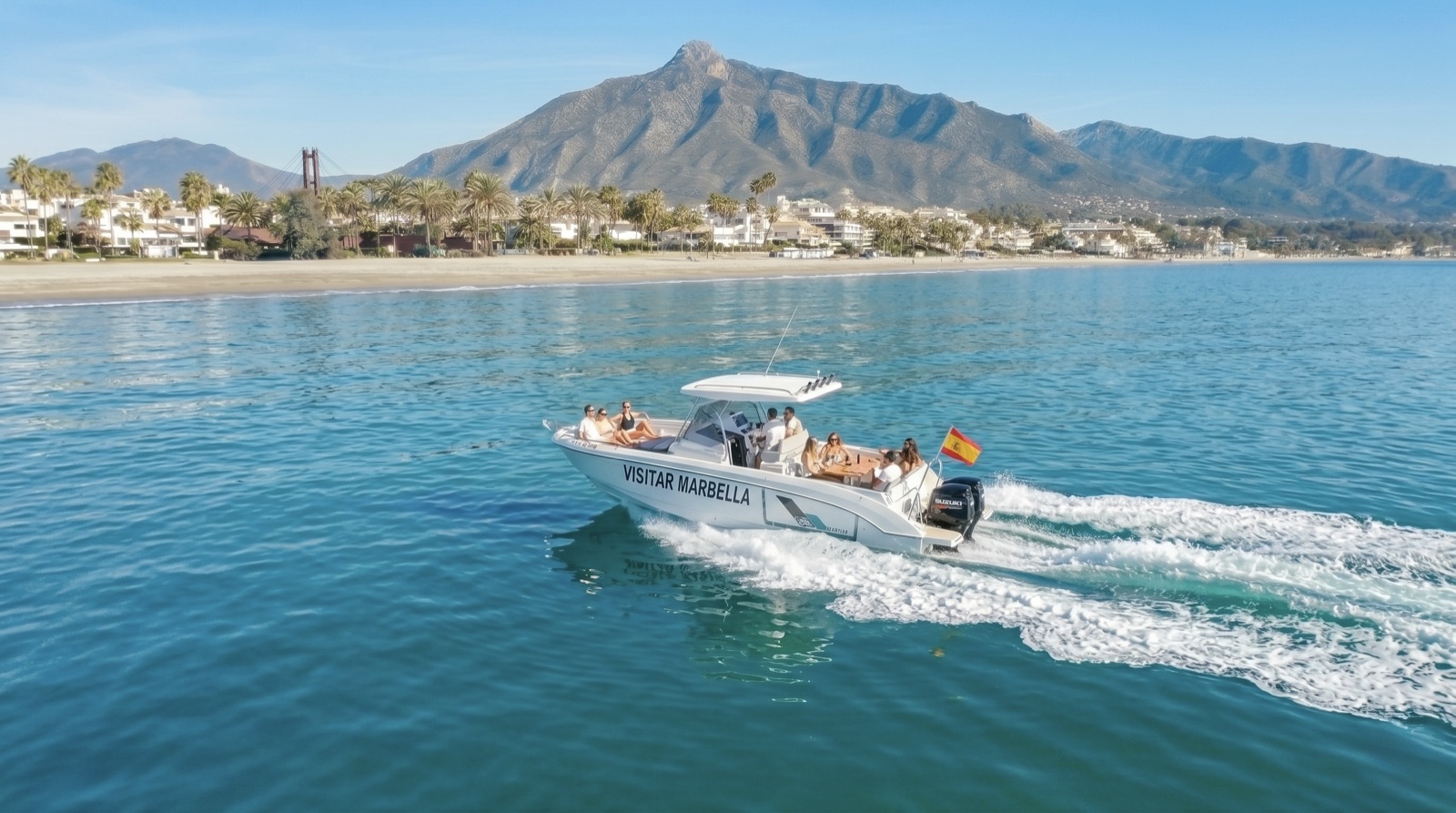 The Visitar Marbella boat cruising the coast below La Concha