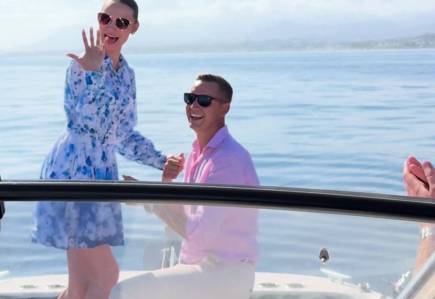 A proposal on the Visitar Marbella boat: he is on one knee, she is showing the ring, the sea behind